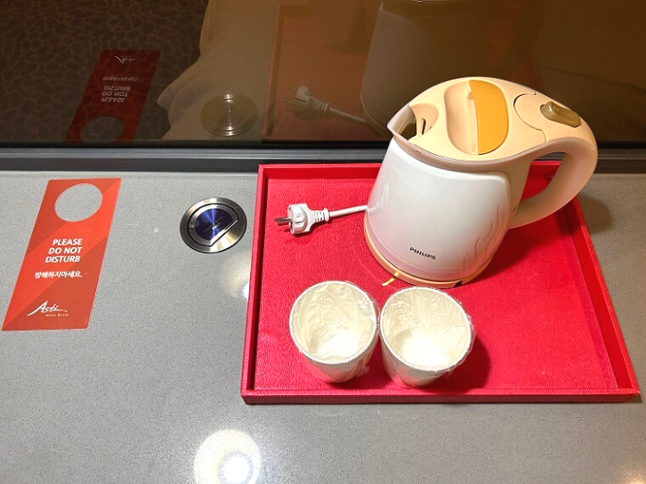 컵과-전기주전자가-있는-회색-테이블-위를-찍은-사진
