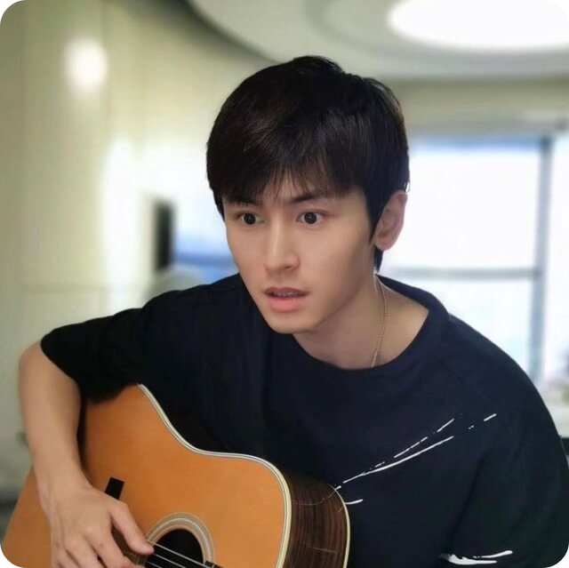 중국 남자 배우 장저한 (Zhang Zhehan)이 검은색 티를 입고 기타를 치고 있는 모습.