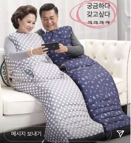 부부가 난방옷을 입고 핸드폰을 하고있는 사진