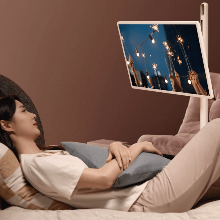 여성이-침대에-누워-LG-스탠바이미-스크린으로-영상을-시청하고-있다.