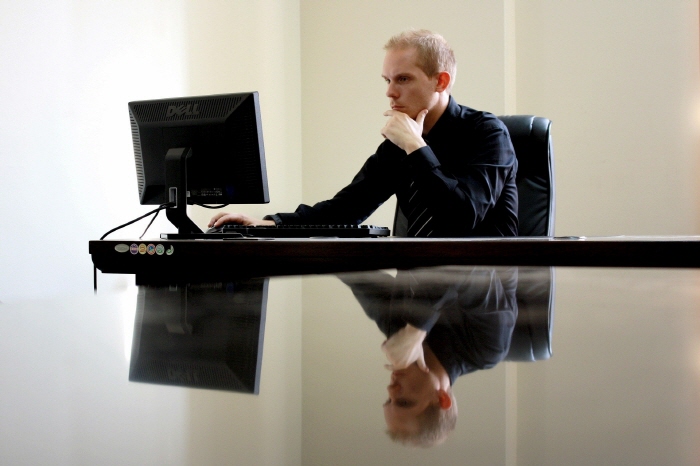 컴퓨터를 보고 앉아 있는 남성