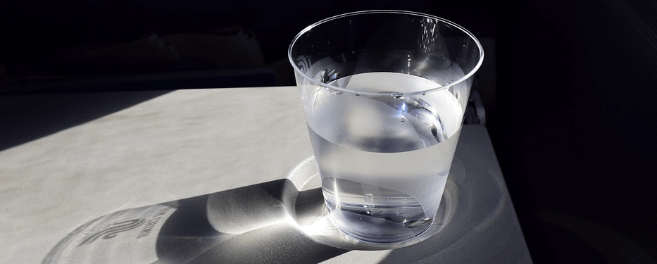 섬네일 테이블 모서리에 놓여 있는 물이 담겨 있는 유리컵