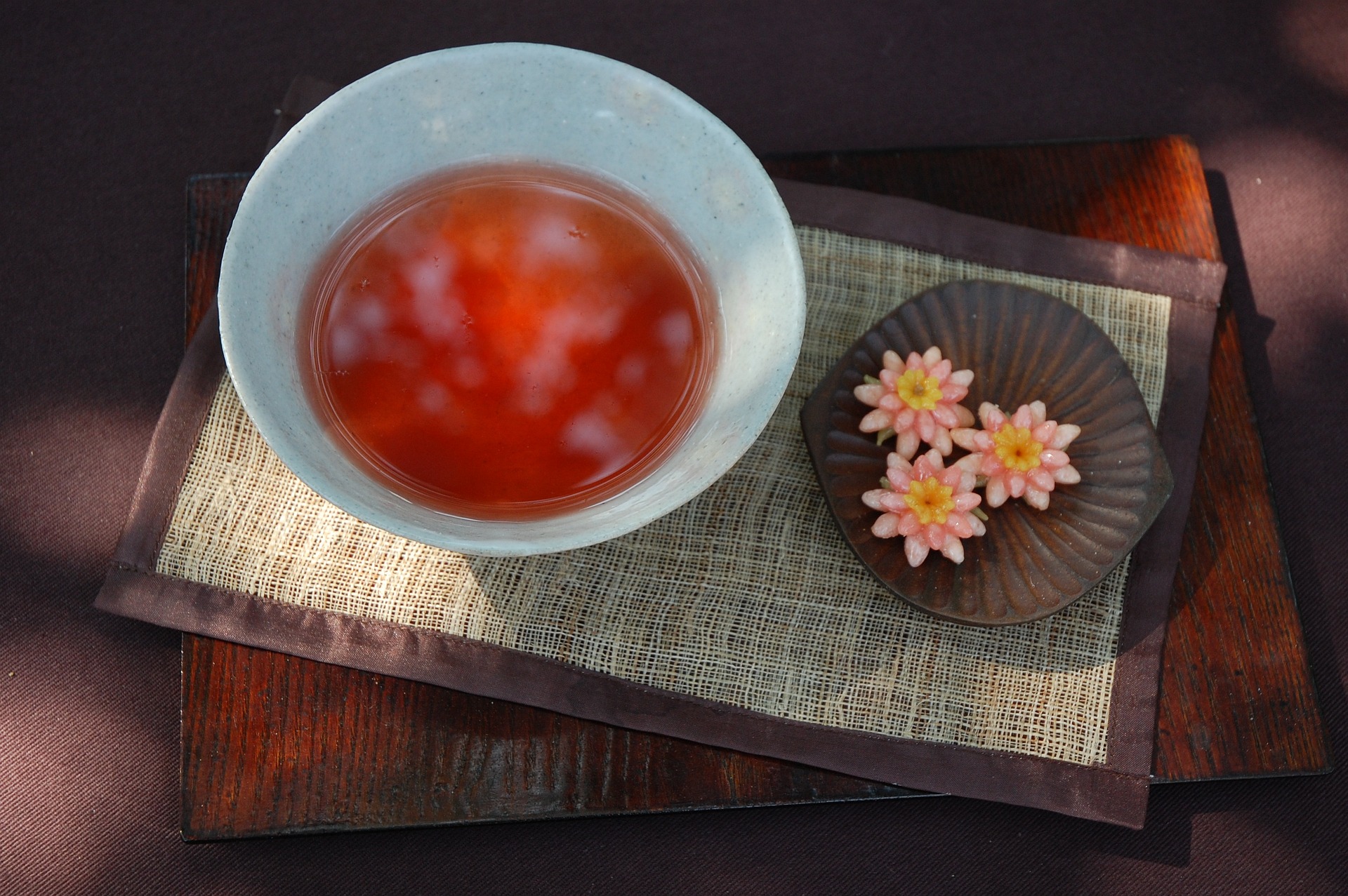 커다란 그릇에 오미자와 물을 넣고 끓여서 만든 오미자차를 담아두고&#44; 그 옆에 꽃 모양의 과자를 놓은 사진