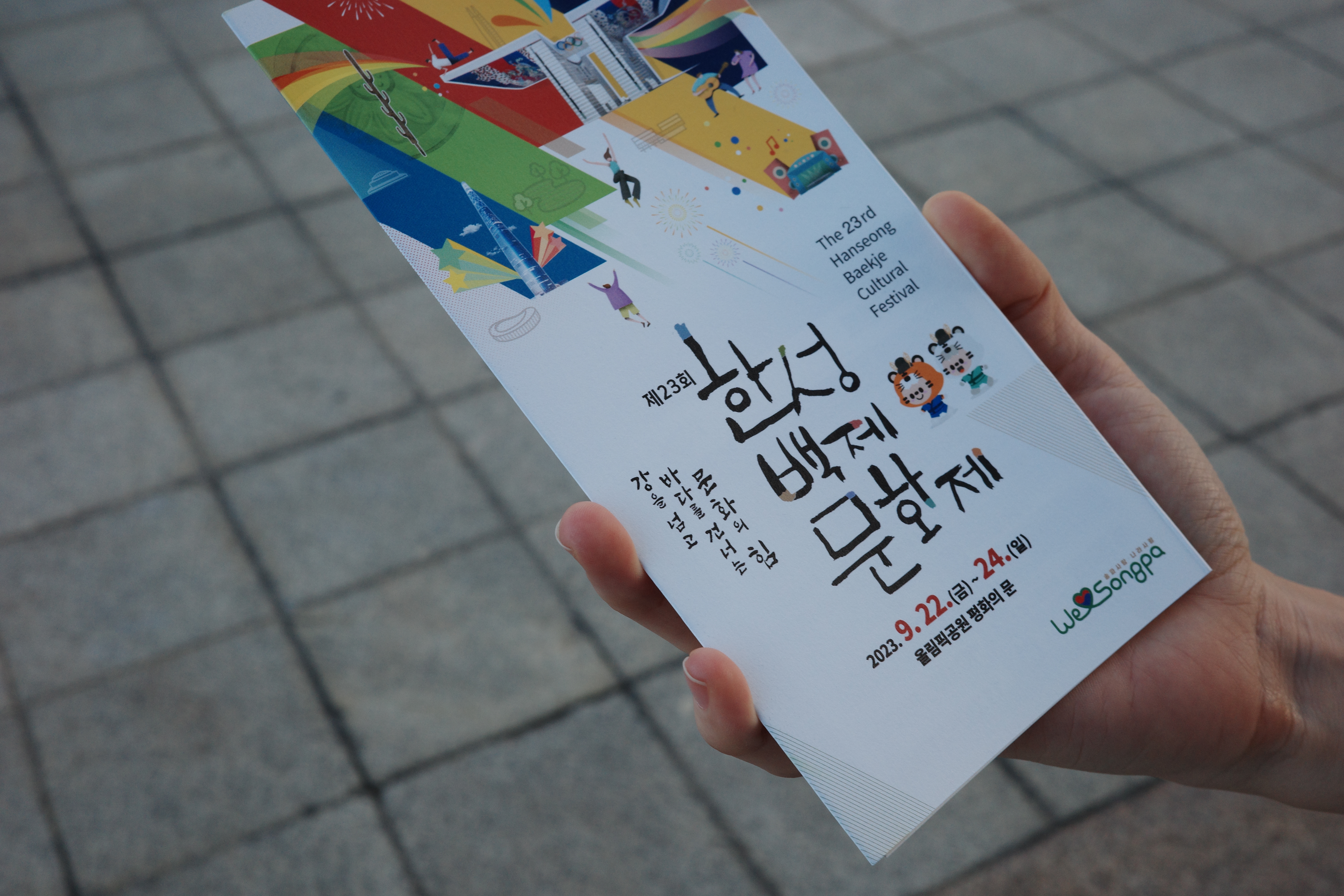 한성백제문화제 팜플렛을 들고 있는 손