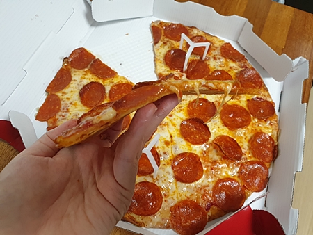 피자 한조각 손으로 들어올린모습