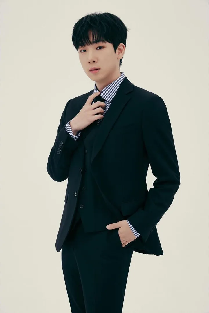 가수 최수호가 정면을 보며 넥타이를 다듬는 사진