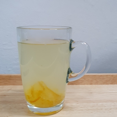 컵에 따뜻한 물과 유자청 한 스푼이 담겨있습니다.