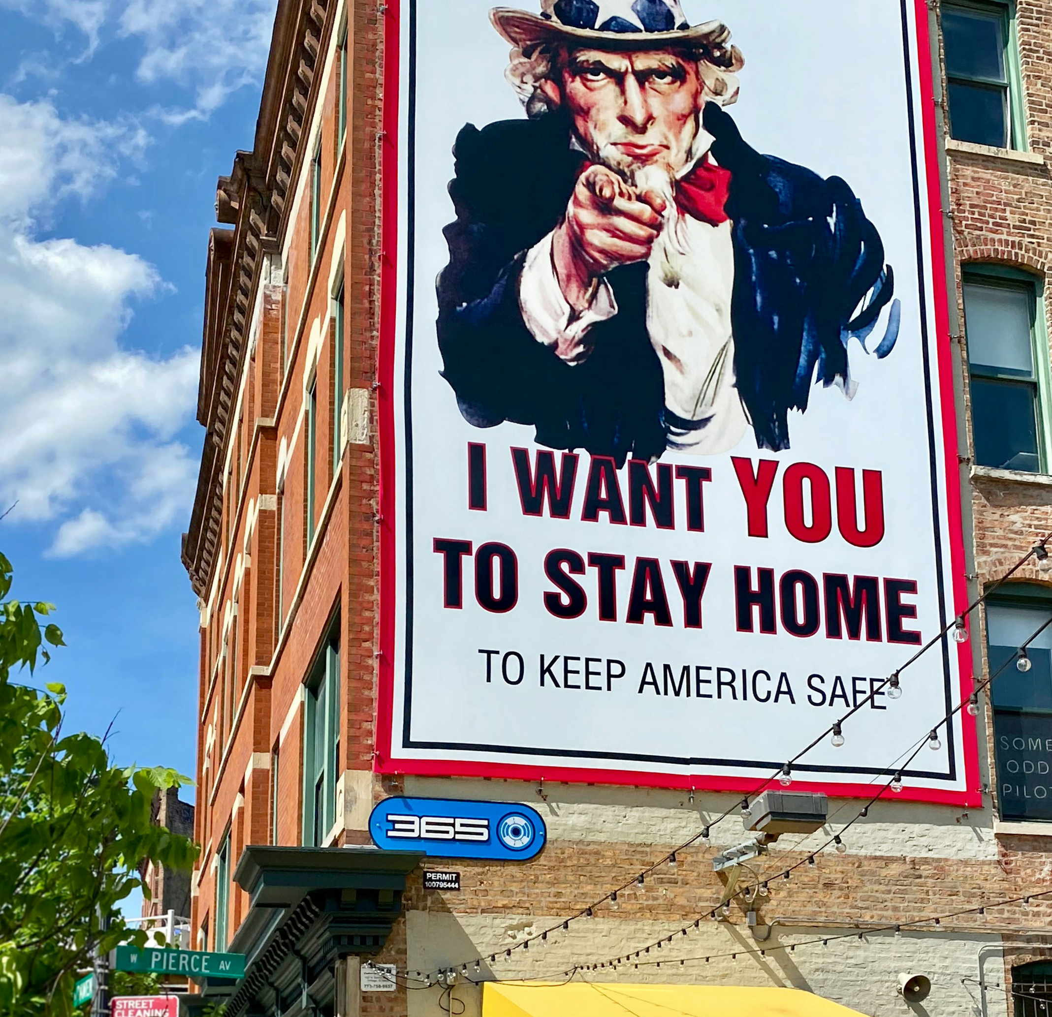미국 어떤 건물 측면에 붙은 큰 포스트. "I want you to stay home to keep America Safe"라고 적혀있다.