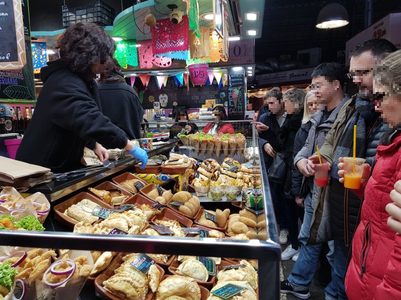 보케리아 시장에서 진열된 음식을 구경하고 있는 사람들