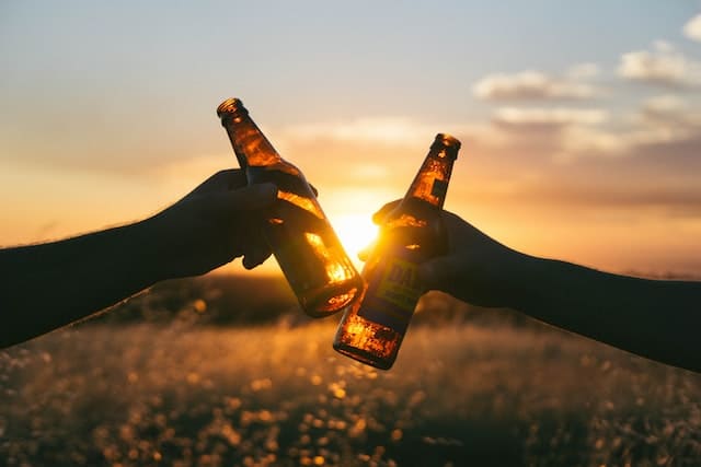 맥주 두 병을 부딪히는 두 사람