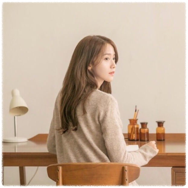 책상에 앉아 뒤를 돌아보고 있는 소녀시대 윤아의 모습