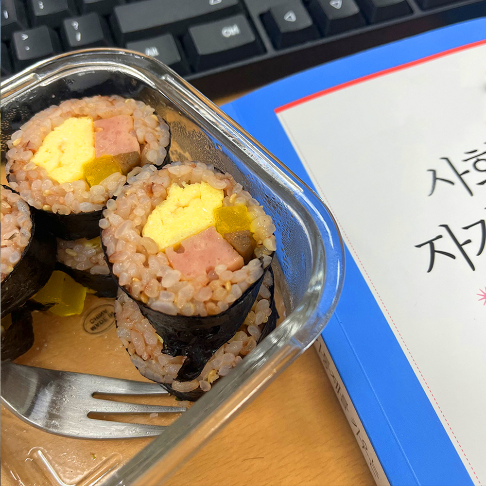 좌측에-김밥이-담긴-그릇이-있고-우측에-책이-놓여-있습니다.(2)