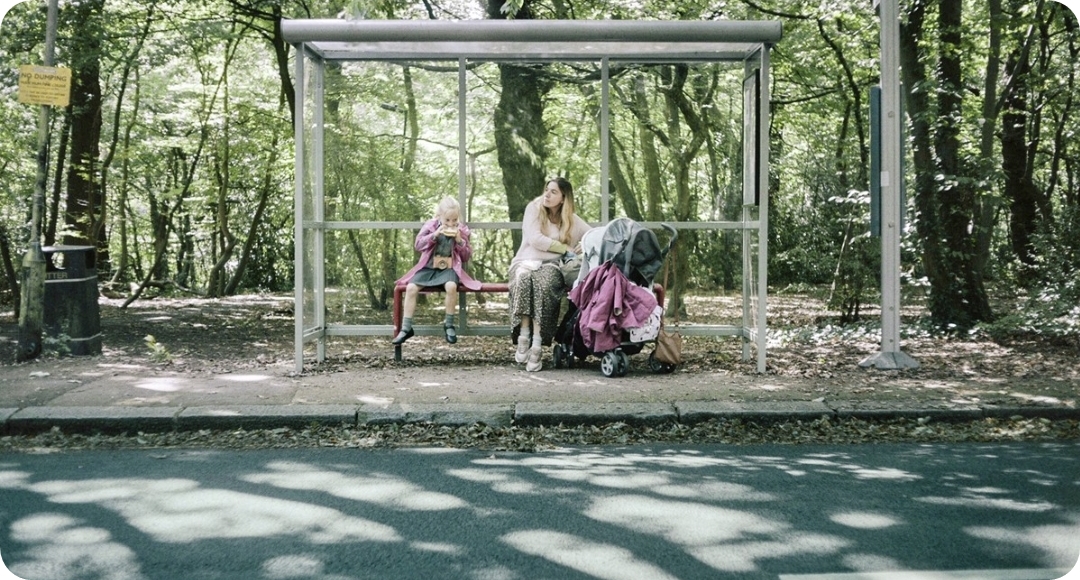 공원에 앉자 있는 여자 아이와 유모차를 잡고 있는 여자 사진