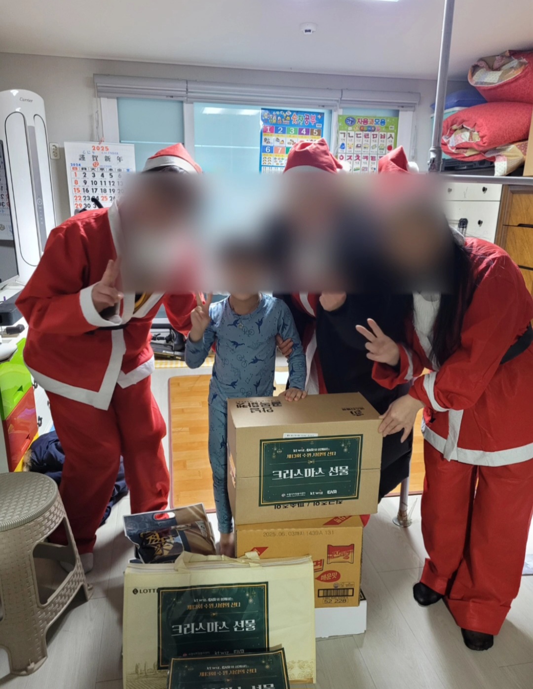 산타 복장을 한 봉사자들이 선물을 전달하며 아이와 함께 찍은 모습
