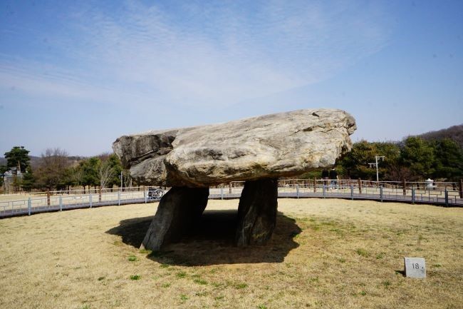 고인돌 근접사진&#44; 비스듬한 받침돌 2&#44; 그 위에 덮개돌&#44; 둥글게 쳐진 울타리&#44;