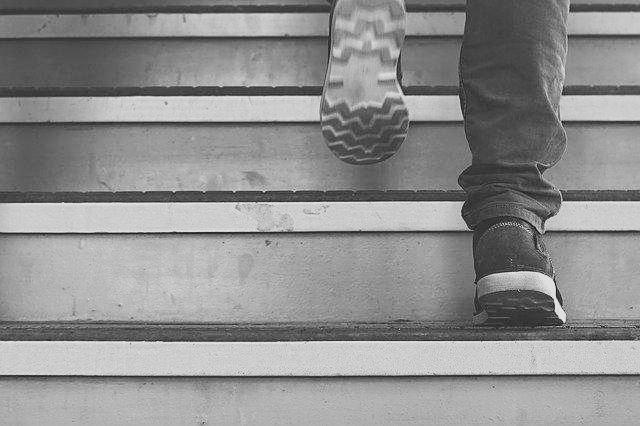 계단을 오르고 있는 사람의 신발과 청바지가 보이는 사진