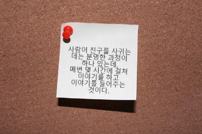 메모판에 꽂혀 있는 흰색 메모지 하나