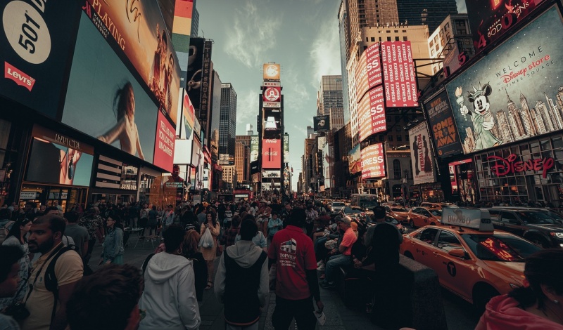 Busy Times Square in New York City filled with people, advertisements, and yellow taxis, representing the bustling energy and diversity of U.S. cities for international students.