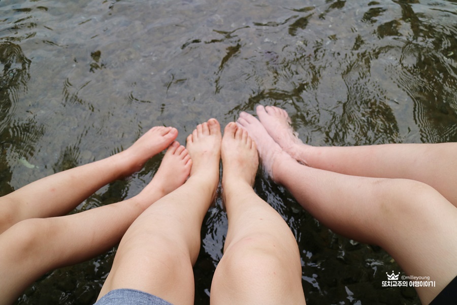 세사람의 발이 물을 담그고 있는 사진