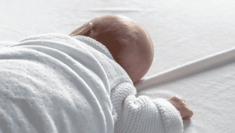 This image captures the theme of sleep and rest that is central to the article. It shows a peaceful moment between a mother and her sleeping newborn&#44; and could help convey the message that it&#39;s important for new parents to prioritize rest and self-care.