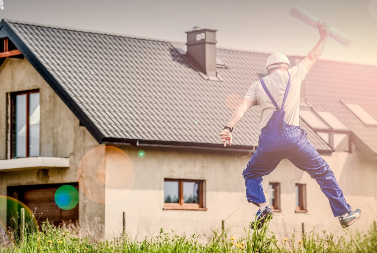 man jumping in joy with his house