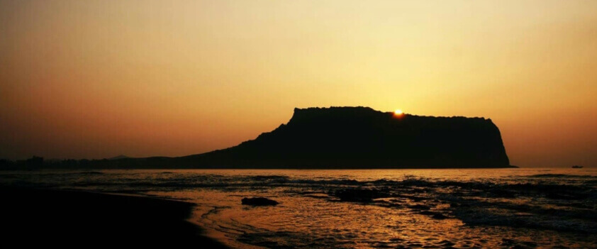 성산일출봉 뒤로 떠오르는 해