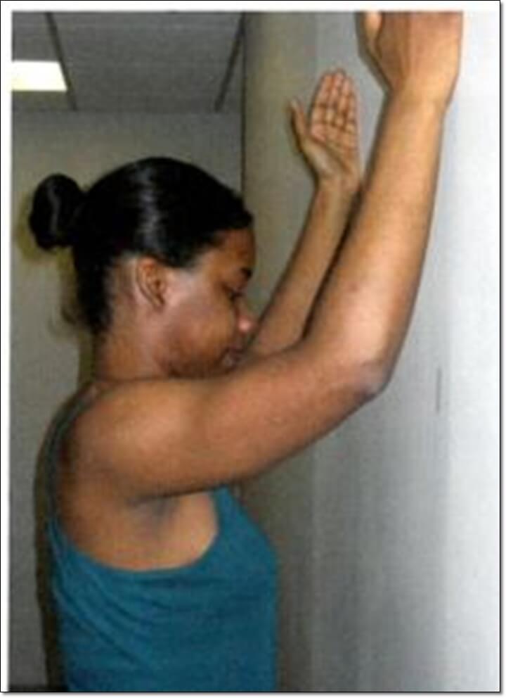 벽에 전완을 대고 있는 상태에서 팔을 위아래로 움직이는 운동을 하는 사진