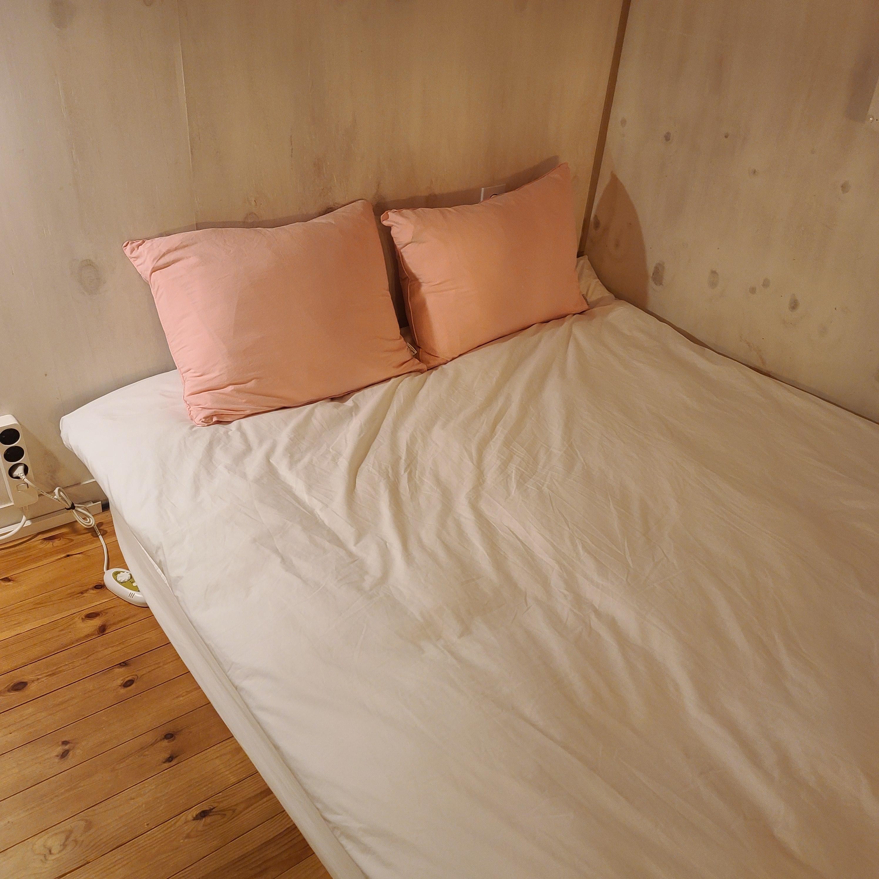 분홍-베개2개가-올려진-침대