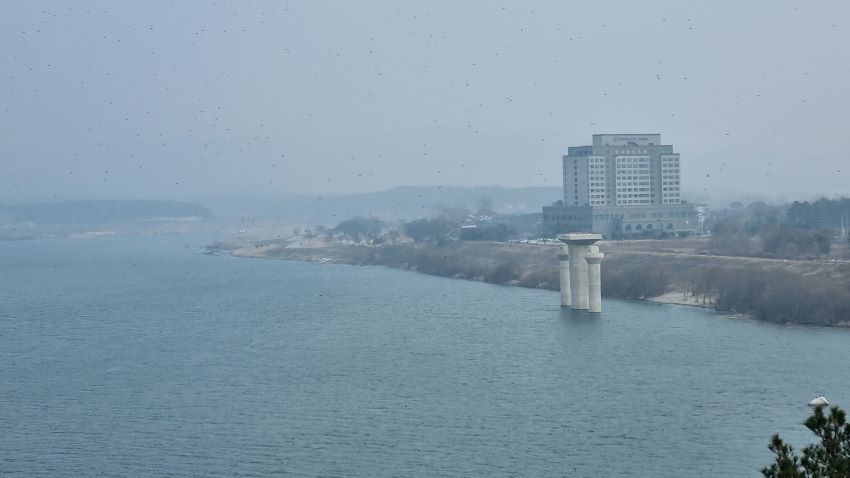 희미한 풍경, 우측 강변에 썬밸리호텔을 당겨찍은 강가 풍경 사진, 앞에는 건설 중인 교각,