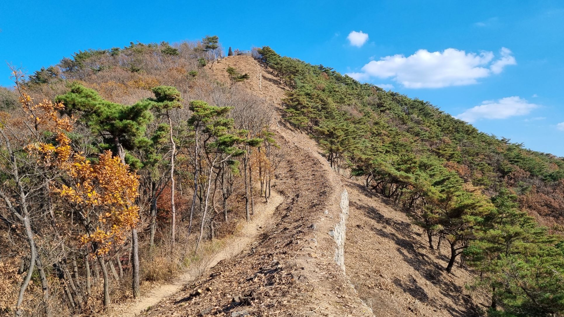 급경사 오르막 동산을 오르는 성곽 길&#44; 푸른 하늘&#44; 흰구름&#44;