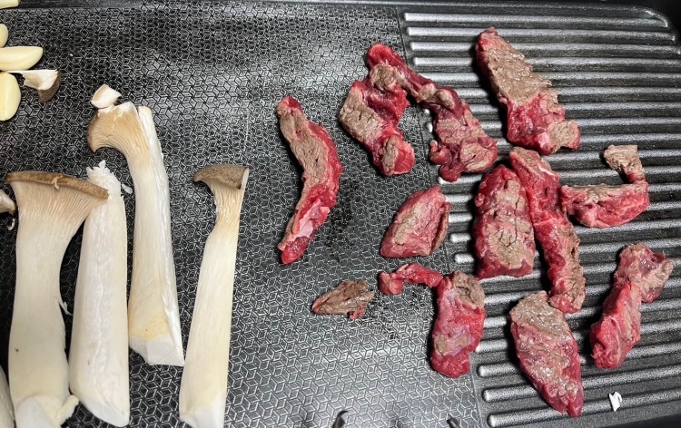 고기들과 버섯과 마늘이 굽혀지고 있는 사진