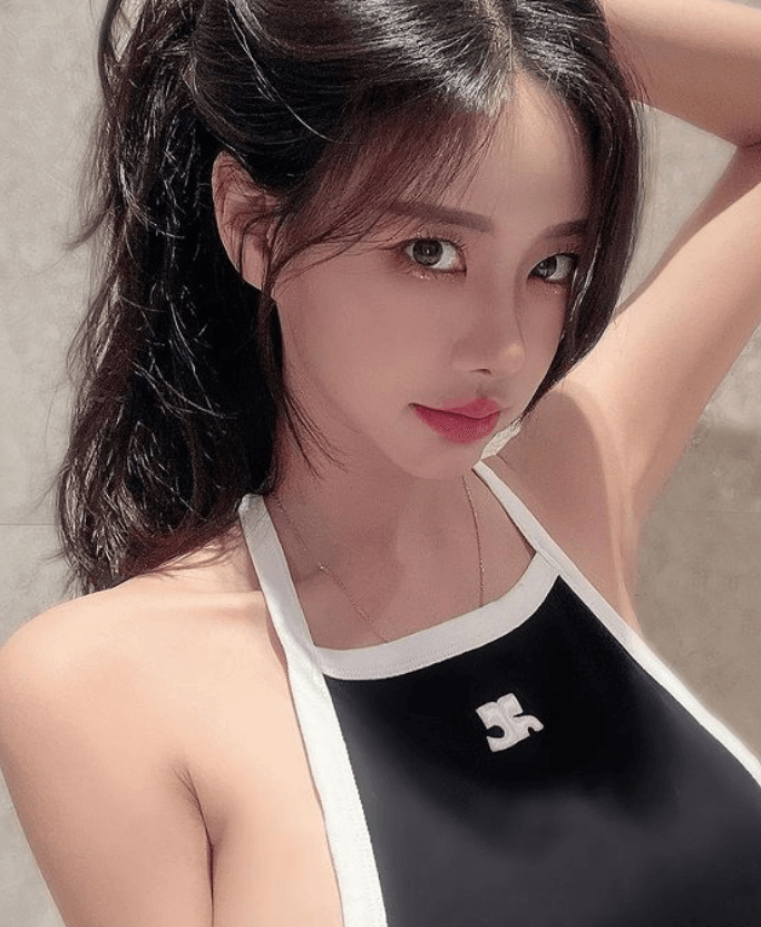김시원이 남색의 탑을 입고 한 손으로 자신의 머리카락을 집어 올리고 있다.