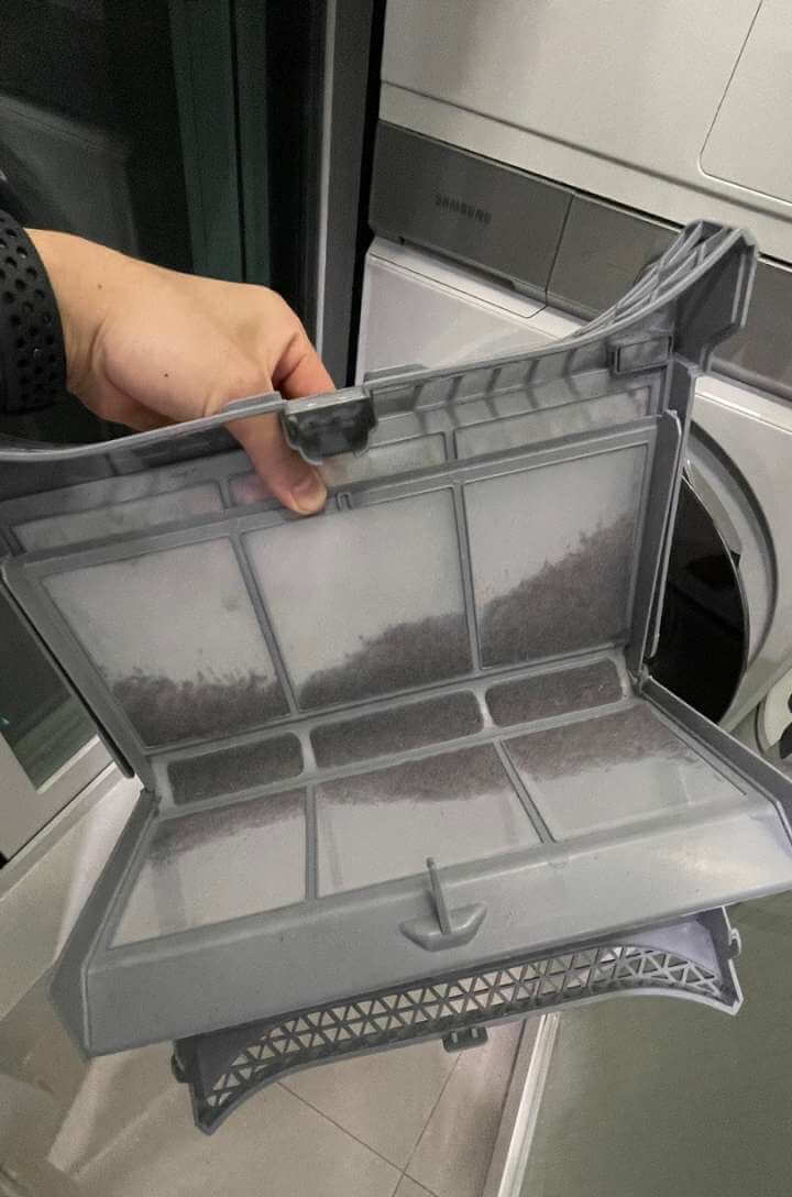세탁기 먼지 필터에 먼지가 잔뜩 쌓여 있다.