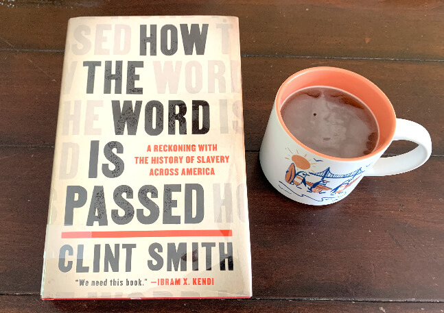 How The Word Is Passed by Cling Smith 책 한권과 머그잔 하나가 있다.