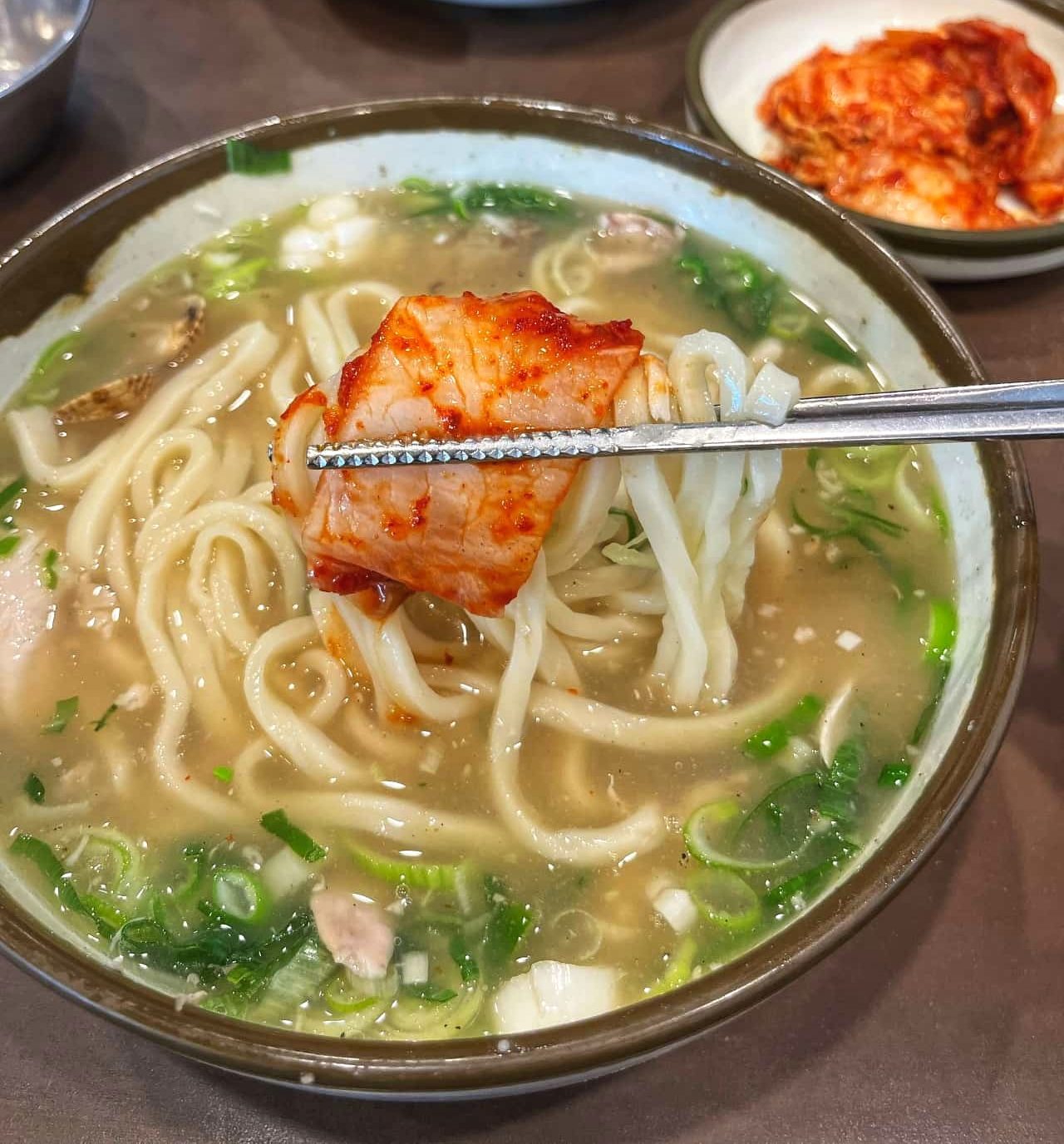 일산칼국수의 닭칼국수를 김치와 함께 먹는 사진