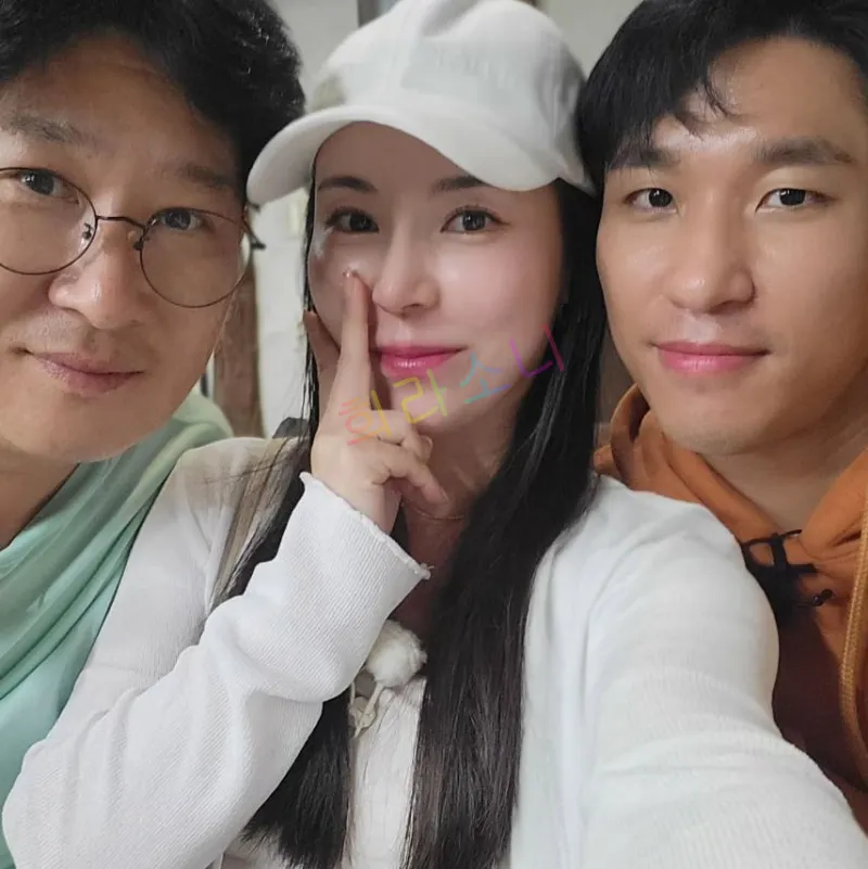 세 명이 함께 셀카를 찍고 있다. 가운데 10기 영숙은 흰색 긴팔 상의를 입고 하얀 캡 모자를 쓰고 있으며&amp;#44; 오른쪽 남성은 미스터 흑김으로 갈색 후디를 입고 있다. 왼쪽 남성은 미스터 백김으로 안경을 쓰고 민트색 후드를 입고 있다. 여성은 손가락으로 코 옆을 가볍게 가리키며 포즈를 취하고 있다. 자막에는 &amp;quot;희라소니&amp;quot;라는 텍스트가 보인다.