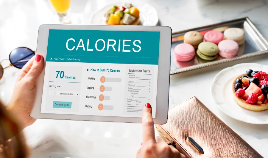 아이패드를 통해서 칼로리를 계산하고 있는 사진(calories-nutrition-food-exercise-concept)