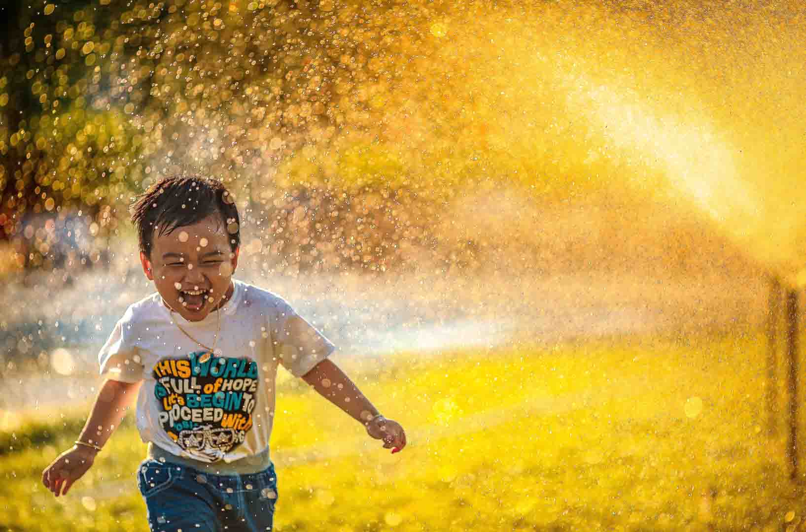 여름의-한낮에-분수의-물줄기를맞고-웃으면서-뛰는남자아이-사진