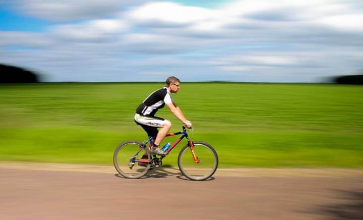 선글라스와-스포츠-의복을-착용하고-자전거를-타고-운동을-하고-있는-사람