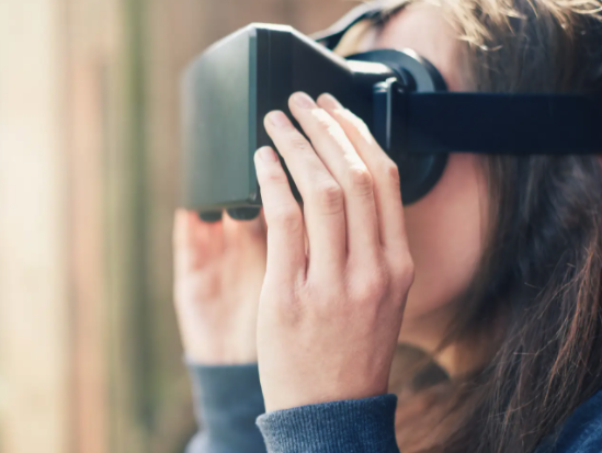 Stock image of a woman using a virtual reality headset. Getty Images