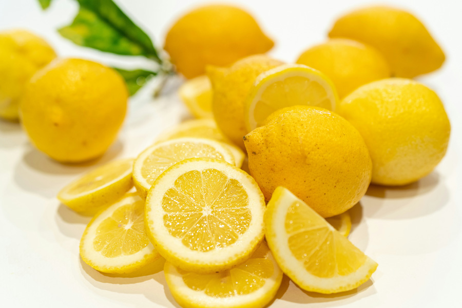 야생에서 채취를 한 레몬을 하얀 바닥 위에 여러 개를 놓아 두고&#44; 맨 앞에는 레몬 1개를 편으로 썰어서 쌓아두고 찍은 사진