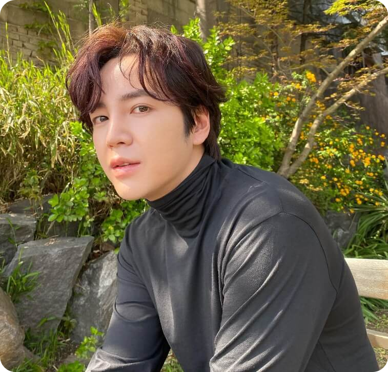 배우 장근석이 회색 티를 입고 앉아 있는 모습.
