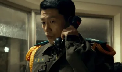 군복을 입고 전화를 받고 있는 영화 서울의 봄에서 이용수를 연기하는 곽진석
