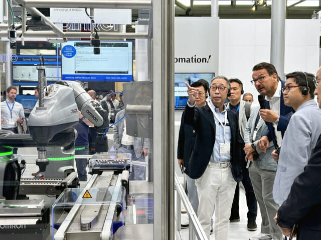‘오토매티카 2023’을 참관한 박지원 두산그룹 부회장(왼쪽)이 한 로봇업체 부스에서 회사 관계자에게 제품에 대해 질문하고 있다.