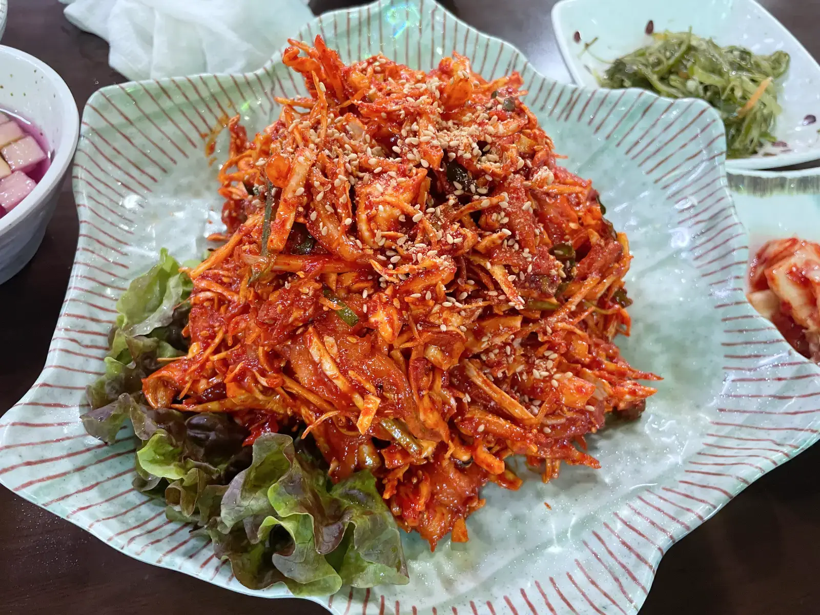 접시에 빨간 밴대이회 무침이 담겨있는 모습