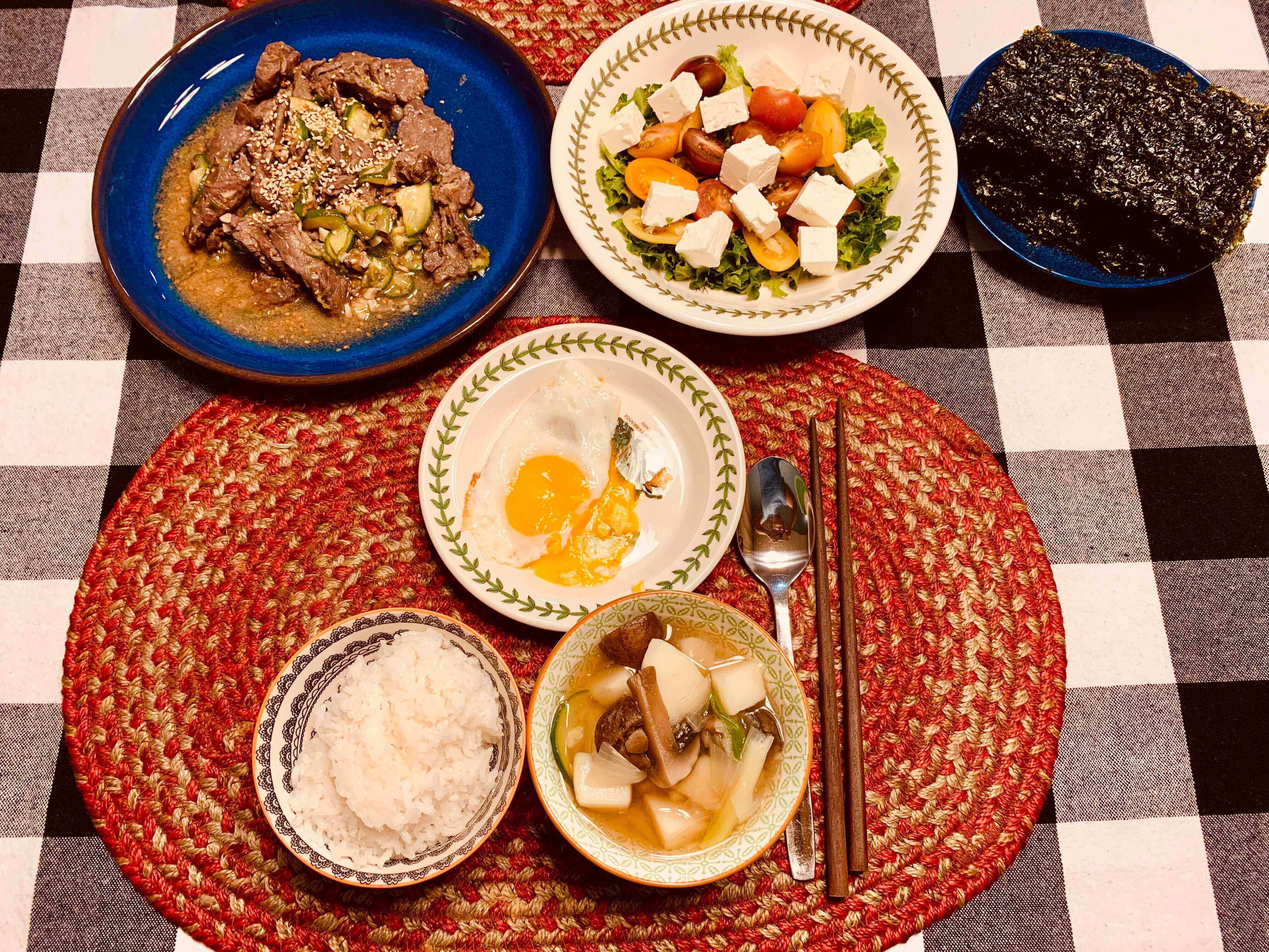 소불고기-토마토-치즈-샐러드-김-계란후라이-흰쌀밥-수저와-젓가락이-셋팅된-식탁-모습