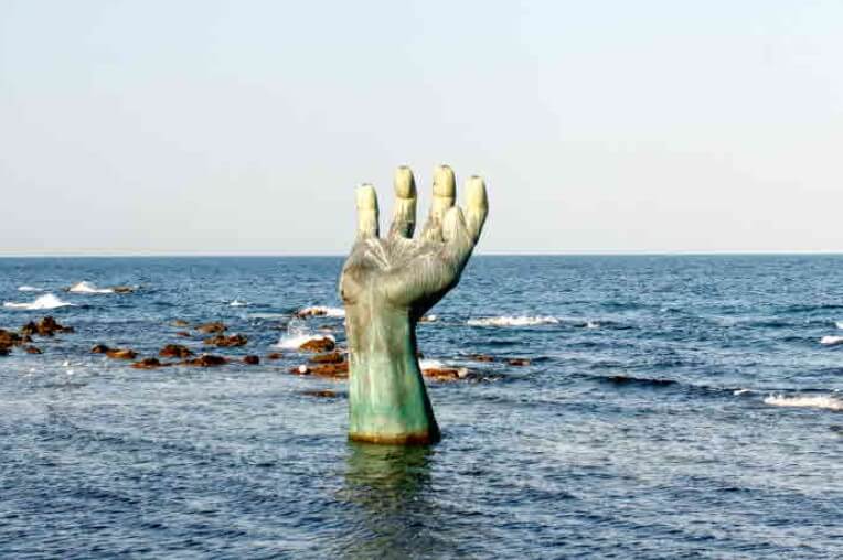 바다-위에-손-모양-동상이-세워져-있다