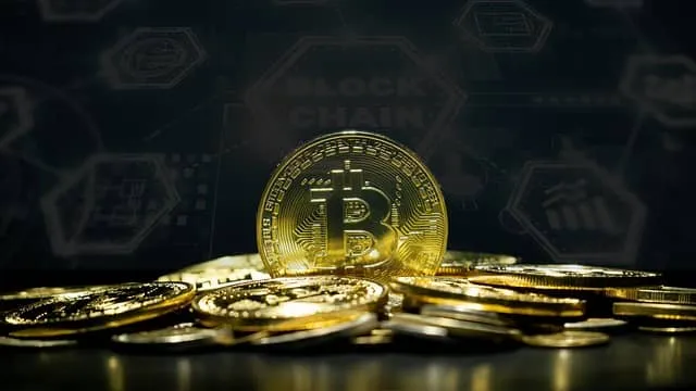 금색 비트코인이 검정색 배경색 위로 흩어져 있는 가운데 한 개의 비트코인이 정면으로 세워져 있다.