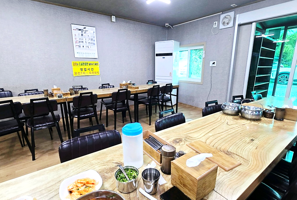 신발 벗고 들어가도록 되어 있고, 많은 입식 테이블이 있는 당진 장춘닭개장 식당 내부 분위기