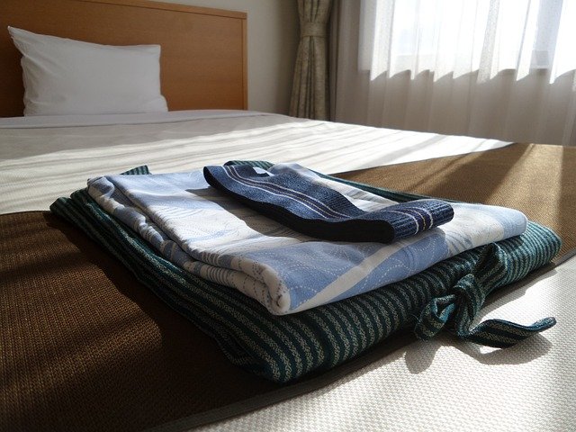 호텔의 침대위에 일본 기모노가 놓여져 있다